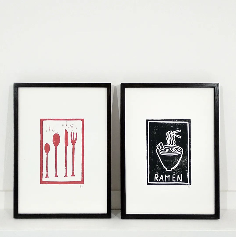 two paintings, showing red cutlery and a ramen bowl framed in solid ash frames stained black