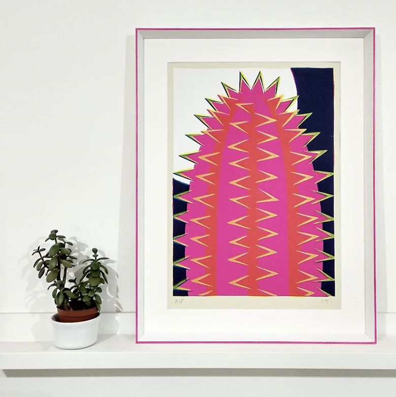 print of pink cactus framed in angled white frame with neon pink highlighted edge